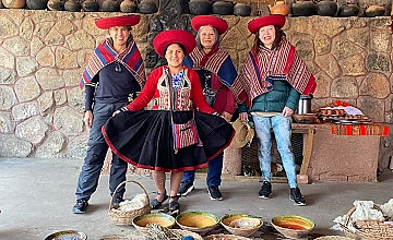 Demostración de cultura andina en Cusco: personas con trajes típicos junto a artesanías y pigmentos