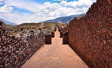 Corredor de piedra en Pikillacta, Cusco, con muros preincas y vista al valle andino